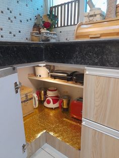 there is a small kitchen with gold glitter on the floor and counter tops in it