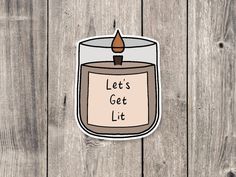 a sticker with the words let's get lit in front of a wooden background