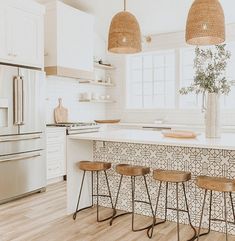 a kitchen with three stools next to an island