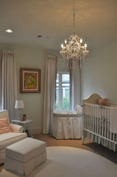 a baby's room with a chandelier and crib