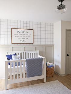 a baby's room with a white crib and blue bedding