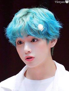 a young man with blue hair wearing a white t - shirt and a pearl brooch