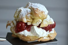 an ice cream and jelly sandwich with powdered sugar on top is sitting on a black plate