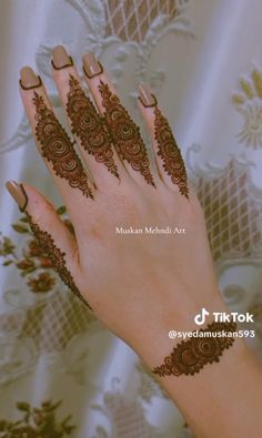 a woman's hand with henna tattoos on it