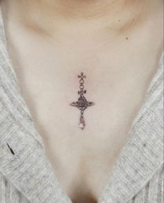 a woman's chest with a cross and star tattoo on her left side ribcage