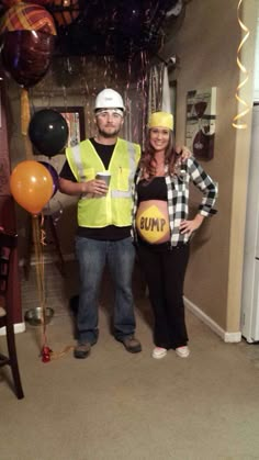 a man and woman standing next to each other in front of some balloons with the word bump written on them