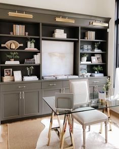 a living room with built in bookshelves and a glass top table surrounded by chairs