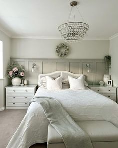 a white bed sitting in a bedroom on top of a carpeted floor next to a dresser