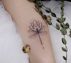 a woman's arm with a dragonfly tattoo on the left side of her body