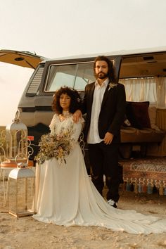 a man and woman standing next to each other in front of a van with the door open