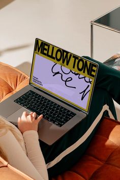 a woman sitting on a couch using a laptop with the word mellowtone on it