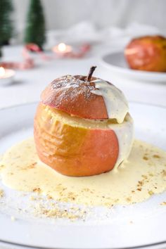 an apple covered in icing sitting on top of a white plate