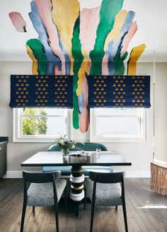 the dining room table is surrounded by colorful art