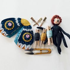 an assortment of crafting supplies laid out on a white surface, including scissors and pins