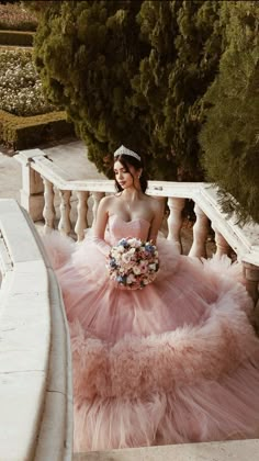 a woman in a pink dress standing on stairs