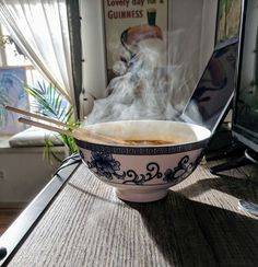 a bowl with chopsticks in it sitting on a table next to a computer