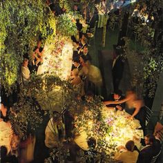 a group of people sitting around a dinner table in the middle of an outdoor area