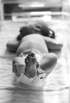 a black and white photo of a baby laying on it's back