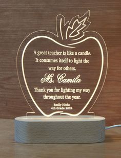 an apple shaped light up with a quote on the front and back side that reads, a great teacher is like a candle if it consumes itself to light the way for others