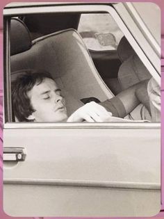 a young man sitting in the back seat of a car