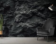 a chair sitting in front of a black rock wallpapered with white paint on it