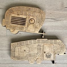 two wooden toy vehicles sitting on top of a wooden floor next to each other with holes in them