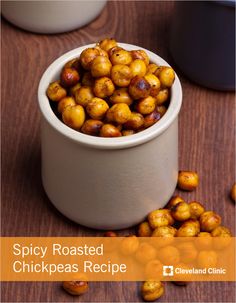 a white bowl filled with chickpeas on top of a wooden table