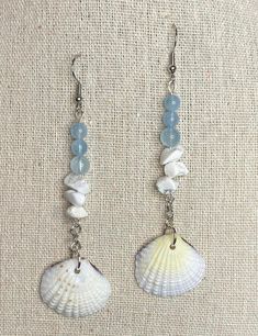 two seashells with blue beads hanging from them