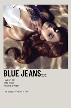 a woman laying on top of a sandy beach next to a white sign that says blue jeans 2012