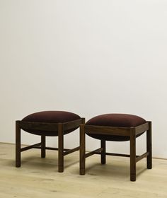 two wooden stools sitting on top of a hard wood floor