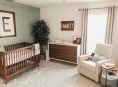 a baby's room with a crib, dresser and chair