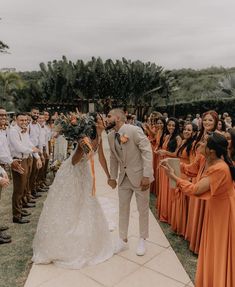 a bride and groom kiss as they walk down the aisle at their outdoor wedding ceremony