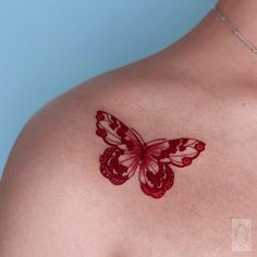 a red butterfly tattoo on the chest