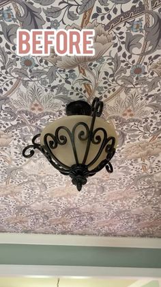 a chandelier hanging from the ceiling in front of a wallpapered background