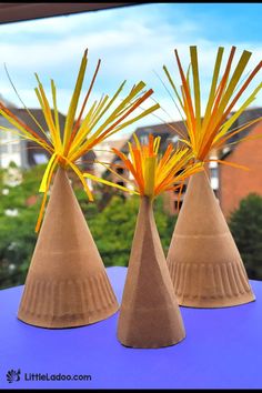 three brown vases with yellow and orange flowers in them on a window sill