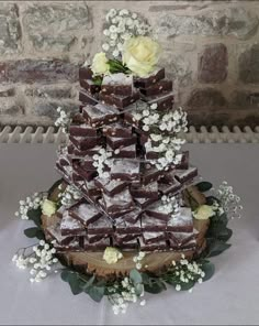 a wedding cake made out of brownies and white flowers