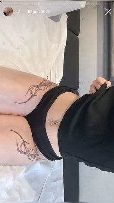 a woman with tattoos on her legs laying down