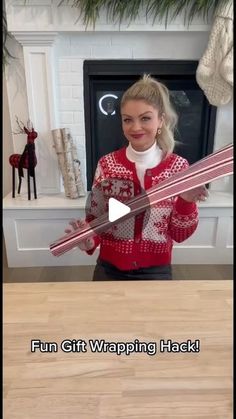 a woman holding two skis in front of a fireplace with the words fun gift wrapping hack