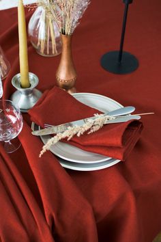 the table is set with red cloth and silverware