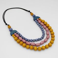 "Discover the beauty of Sylca Designs' handcrafted Wood Bead Cailee statement necklace! This artistic piece features a stunning triple strand design, carefully strung with captivating wood beads in hues of orange, blue, and wine. Each necklace is uniquely handcrafted, making it a wearable work of art. Whether you're dressing up for a special occasion or adding a pop of color to your everyday look, this comfortable and lightweight design on an adjustable cord is sure to be your go-to accessory. A Blue Multi-strand Wooden Bead Necklaces, Handmade Orange Multi-strand Necklace, Adjustable Orange Multi-strand Necklaces, Handmade Multicolor Multi-strand Layered Necklace, Multicolor Handmade Multi-strand Layered Necklace, Colorful Necklace, Bold Necklace, Necklace Colorful, Necklace Ideas