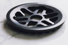 a close up of a metal object on a marble surface with holes in the center