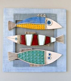 three ceramic fish on a gray background