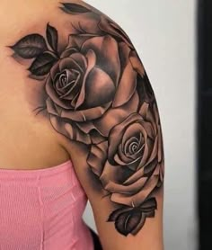 a woman's shoulder with black roses on her arm and the other half sleeve