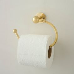 a gold toilet paper holder on the wall