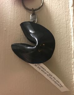 a key chain hanging from the side of a wall with a piece of paper attached to it