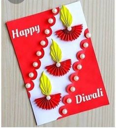 a handmade diwali card with red and yellow paper flowers on the front