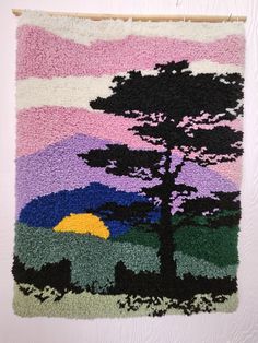 a rug hanging on the wall with a tree