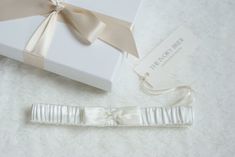 The Victoria Garter, made from soft Ivory satin with a Ivory satin handcrafted bow to center, finished with silver bead detailing. Every garter Is handcrafted here In England, all fabric and lace is hand cut, all embellishments and decoration and each bead is carefully hand sewn on to give a complete authentic handcrafted product. Each Garter is presented In a quality keepsake gift box finished with a luxurious satin ribbon bow, your garter will be safely wrapped inside the gift box in acid free Stock Tie, Satin Ribbon Bow, Pearl Pin, Bridal Garter, Satin Wedding, Silver Bead, Satin Bow, Keepsake Gift, Dressage