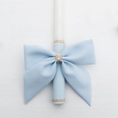 a white candle with a light blue bow on it