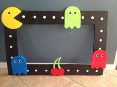 a photo frame decorated with paper mache and cut out pacman's faces